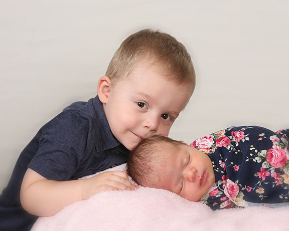 Child and newborn pose